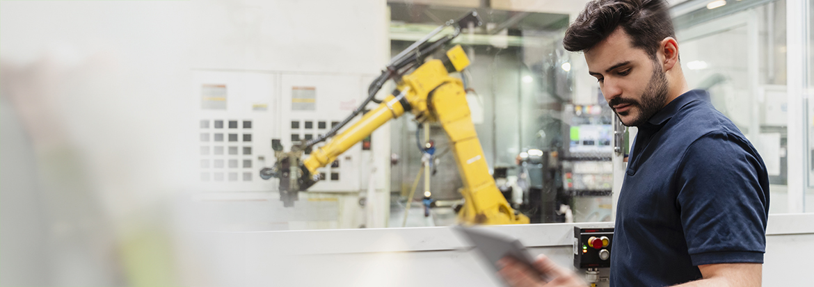 Homme avec tablette et robot en arrière.