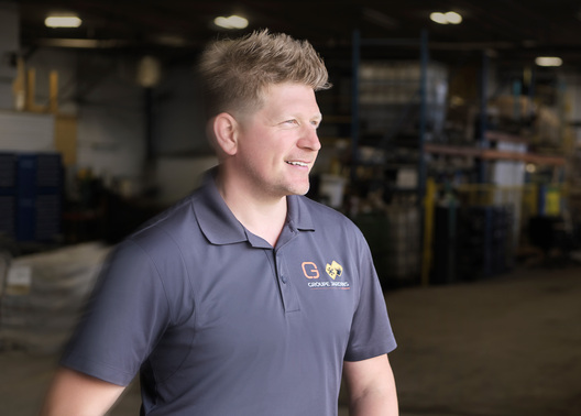 Olivier Girard smiling and standing in warehouse of Groupe Jardins Brossard