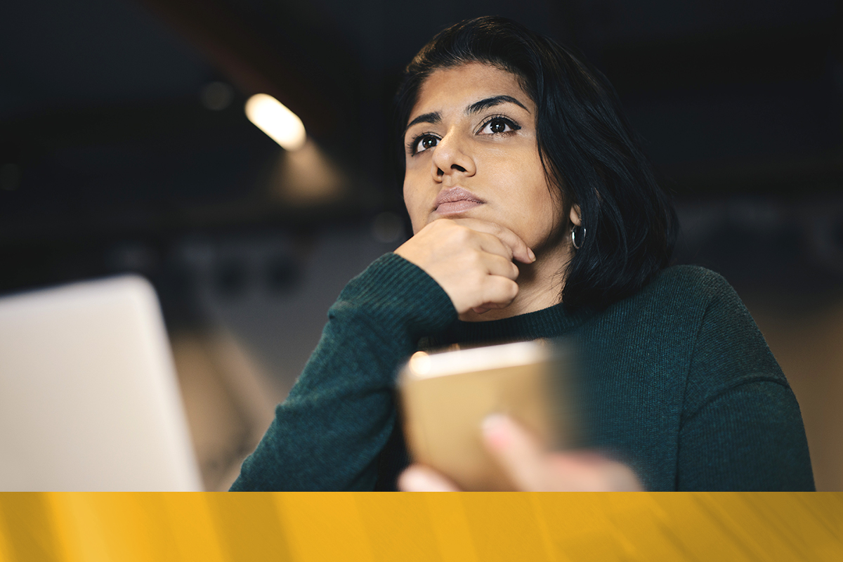 Woman lost in thoughts in front of laptop late at night

