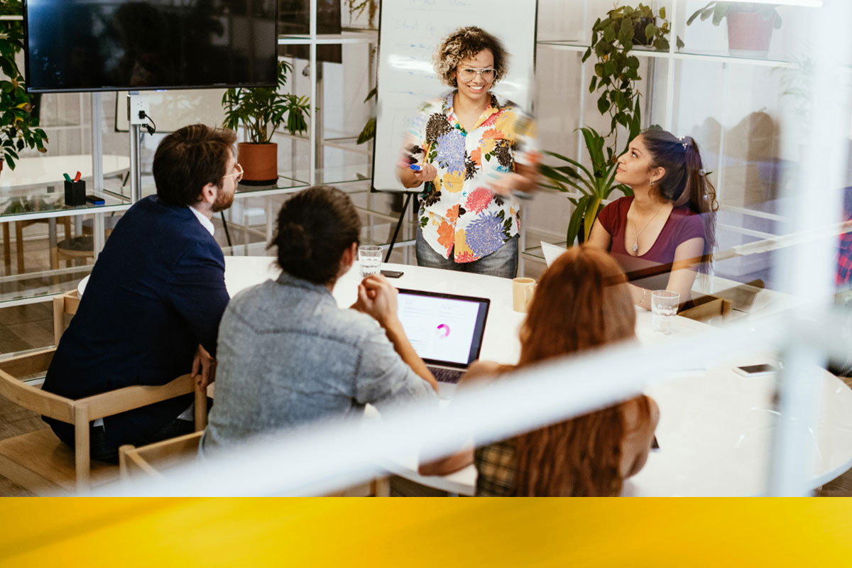 Team meeting of 5 people of various age and ethnicity in a modern office