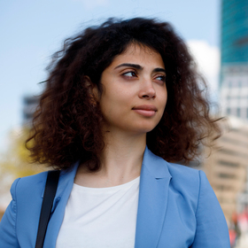 Femme d'affaires aux cheveux bouclés regardant devant dans la rue.